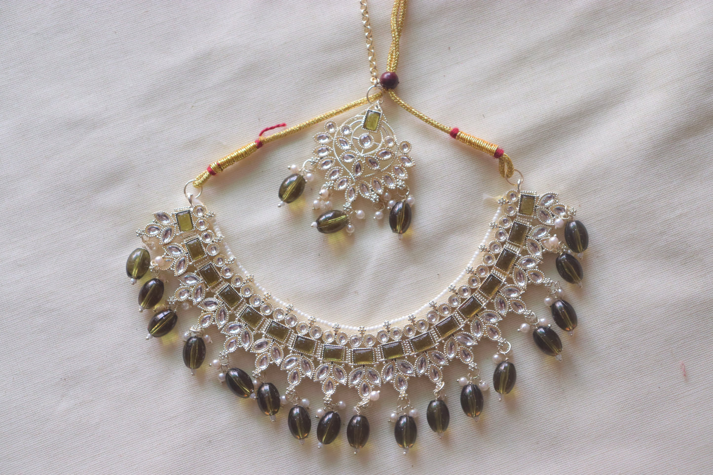 Necklace with Green studded stones along with tiara and earrings
